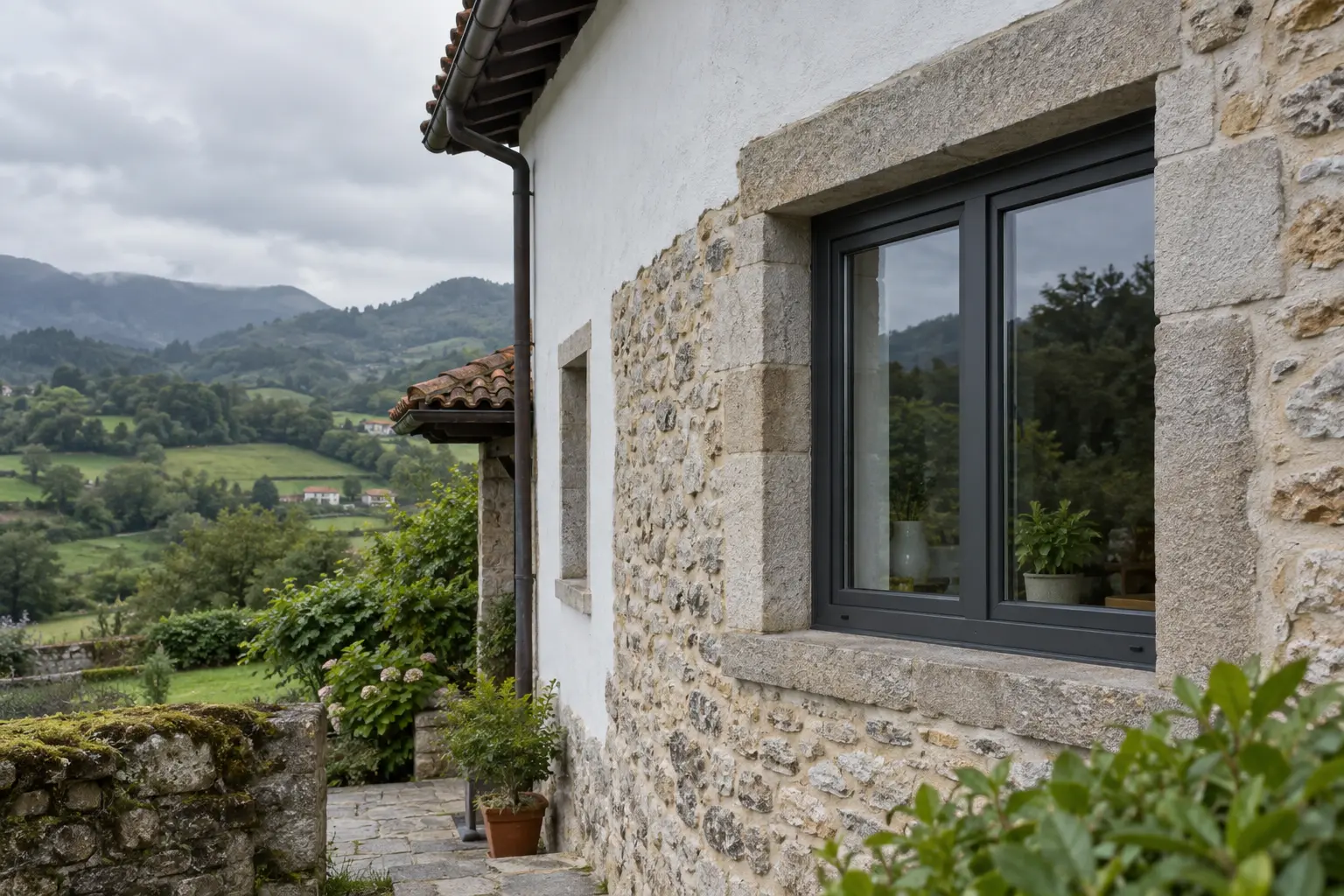 Illustrative stone house with an anthracite PVC window in a green northern Spanish landscape